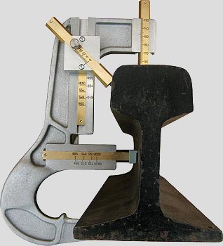 Rail profile gauge positioned against a section of rail